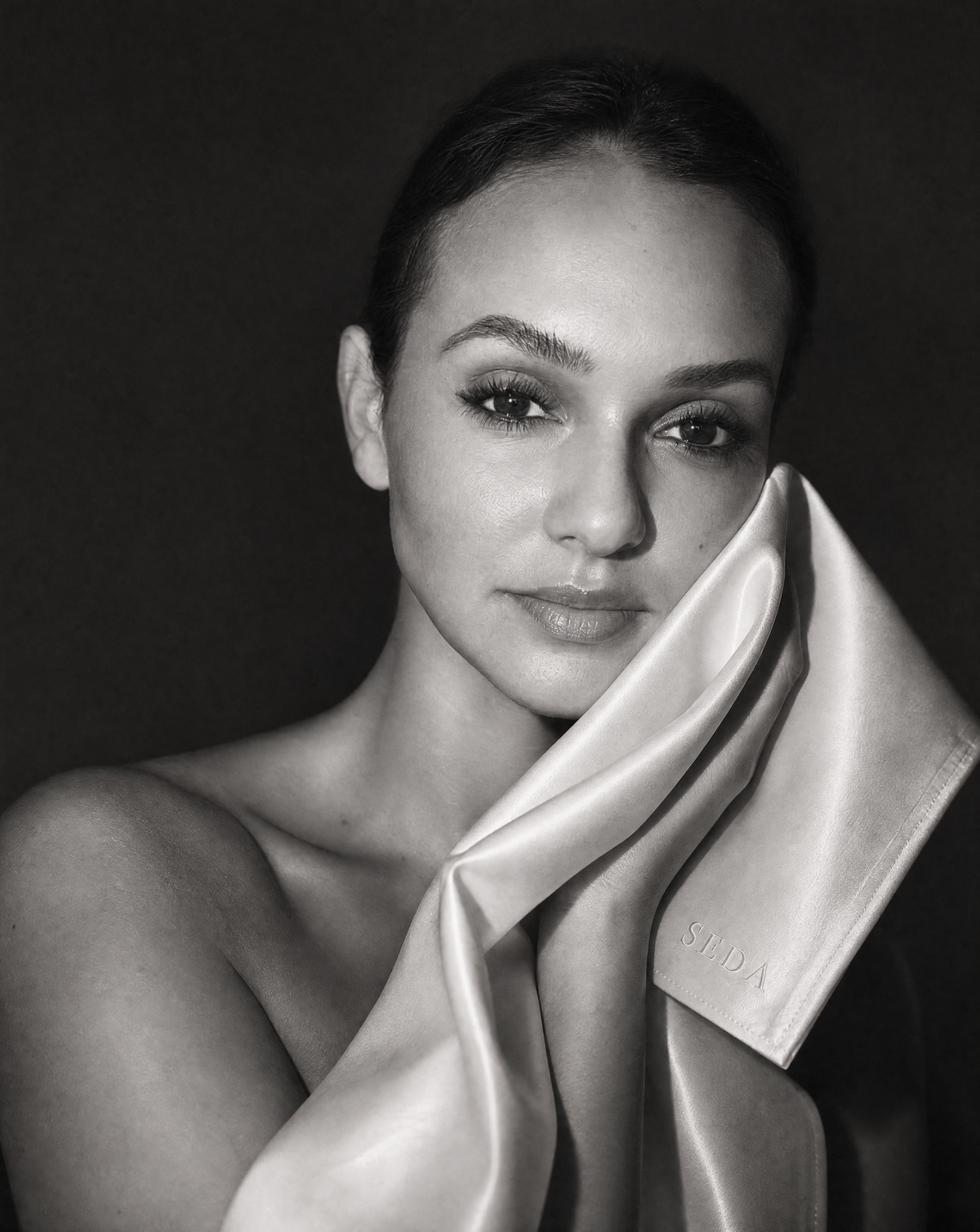 A champagne SEDA silk face cloth being pressed gently against the face after cleansing